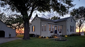 A two-story house with a front porch, a garage, and a well-maintained lawn. - A Sisters Stay Farmhouse Retreat in Villa Ridge (Villa Ridge)
