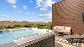 Ein Whirlpool auf einem Balkon mit Blick auf eine Berglandschaft.