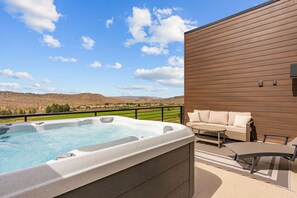 Ein Whirlpool auf einem Balkon mit Blick auf eine Berglandschaft.
