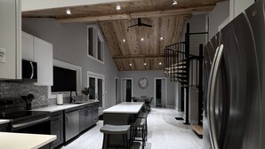 A modern kitchen with a central island, stainless steel appliances, and a wooden ceiling. - Finger Lakes, Wine Country, Modern Escape (Montour Falls)