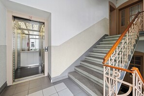 A staircase with a handrail and a door leading to an elevator. - SOLARIS - Vacation rental, sleeps 2, Old Town, kitchen, parking, Elbe River, S-Bahn, Wi-Fi (Meißen)