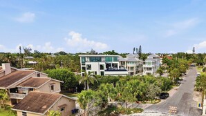 Zona residencial con casas modernas, una calle y palmeras.