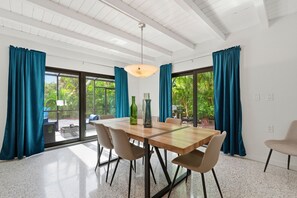 Un espace repas comprenant une table en bois, des chaises et un luminaire suspendu.