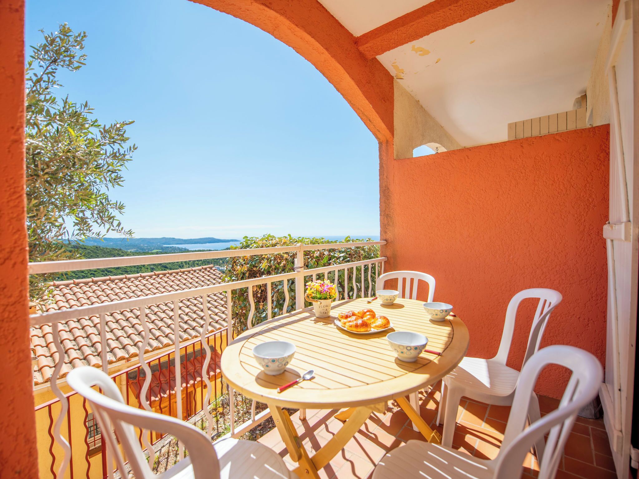 A balcony with a table, chairs, and a view of the landscape.