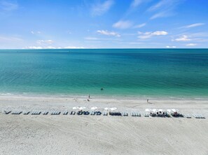 A beach with rows of sun loungers and umbrellas, a clear sky, and calm sea. - Welcome to F203, 2br/2bath, Sundial of Sanibel, a relaxing beach condo, resort-style amenities, and easy access to sand, shells, dining, and island fun. Perfect for a Sanibel getaway with comfort, convenience, and coastal charm. 3-7night minimum (Sanibel Island)