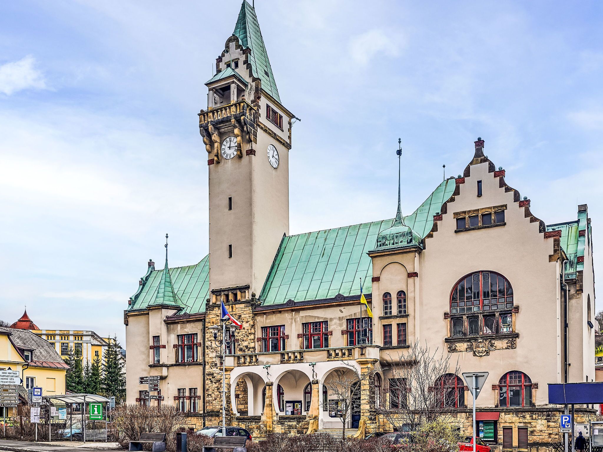Ein historisches Gebäude mit einem Glockenturm, Rundbogenfenstern und einem begrünten Dach.
