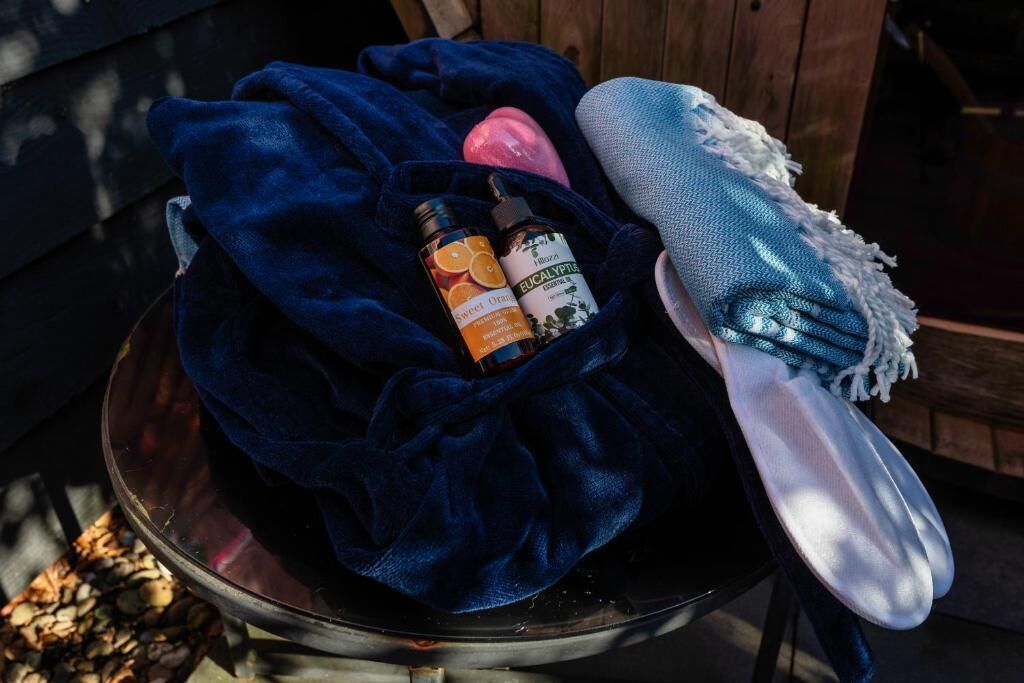 A bowl with a dark blue cloth, a white cloth, and two bottles with labels.