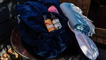 A bowl with a dark blue cloth, a white cloth, and two bottles with labels.