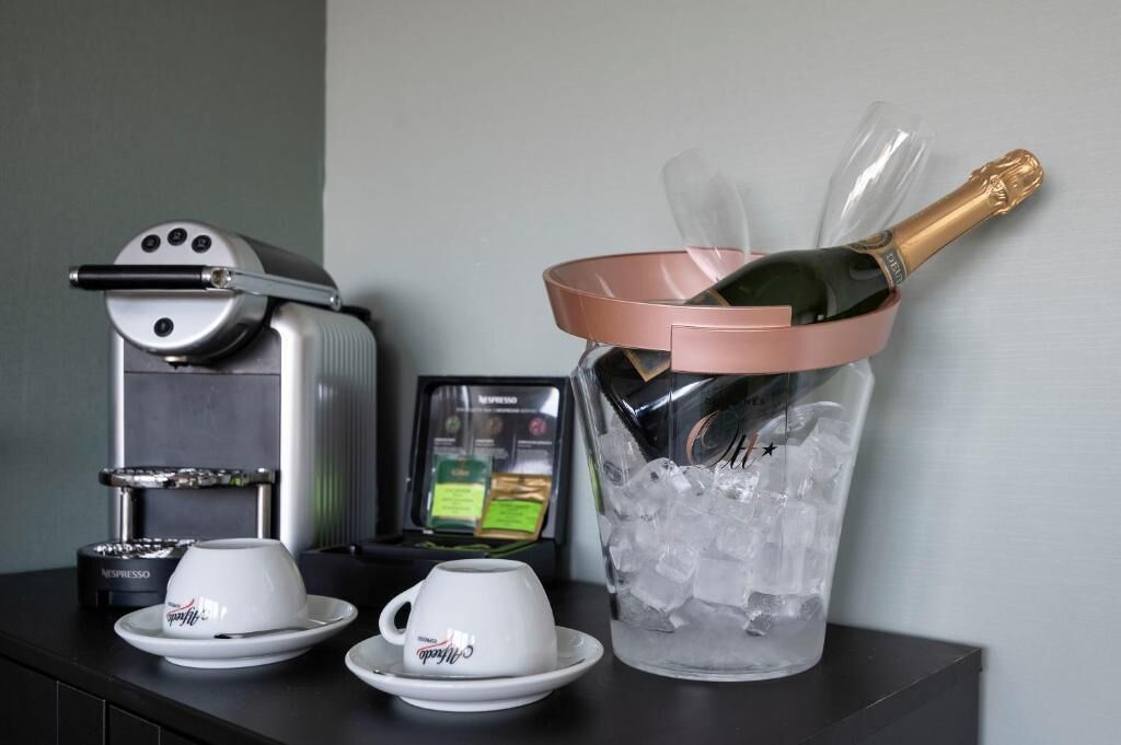 A coffee machine, two cups, and a champagne bucket with ice.