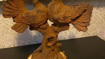 A wooden sculpture of two birds perched on a tree branch.