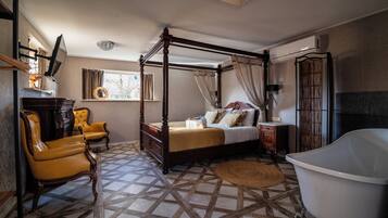 A four-poster bed, a clawfoot bathtub, and a patterned floor.