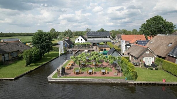 A riverside area with buildings, a small garden, and a canal.