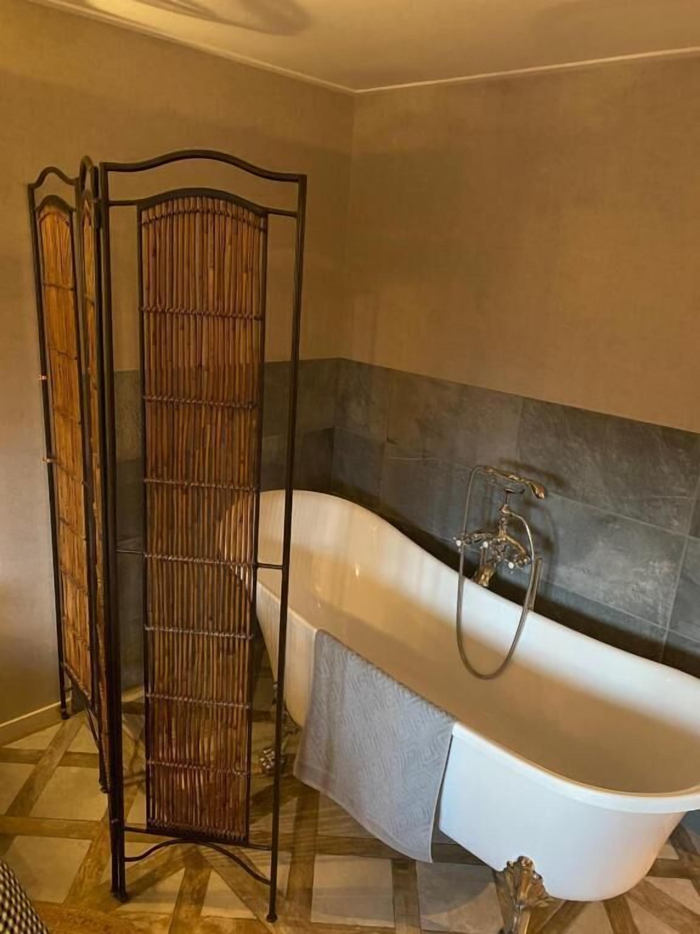 Un baño con bañera, cortina de ducha y suelo de baldosas.