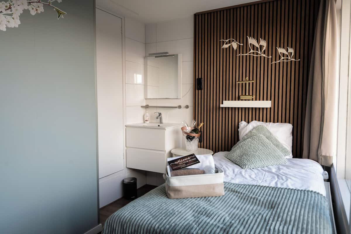 A modern bedroom with a bed, bedside table, and a nightstand.