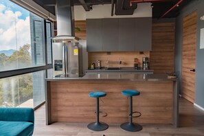 Una cocina moderna con barra, ventanas amplias y vistas al exterior.