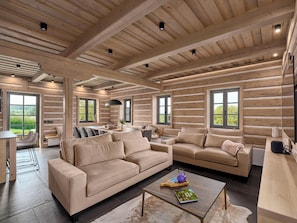 A log cabin interior with a sofa, coffee table, and dining area. - Chalupa Dva by Interhome (Roprachtice)