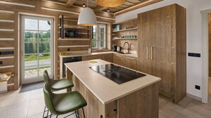 A modern kitchen with wooden cabinetry, a central island, and pendant lighting. - Chalupa Raz by Interhome (Roprachtice)