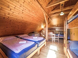 Una cabaña de madera con dos literas, una mesa de comedor y una silla.