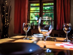 Una mesa de comedor con dos copas de vino, un plato y un tenedor.