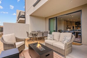 An outdoor patio with wicker furniture, a fire pit, and a view of the interior. - Isle Stay Awhile 5 Bedroom Townhouse (Washington)