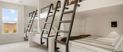 A bunk bed room with a ladder, a window with a view, and a white wall.