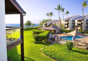 Ein Hotel mit Pool, Palmen und Meerblick.