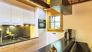 Eine moderne Küche mit schwarzem Arbeitsplatz, weißen Schränken und einem Fenster.