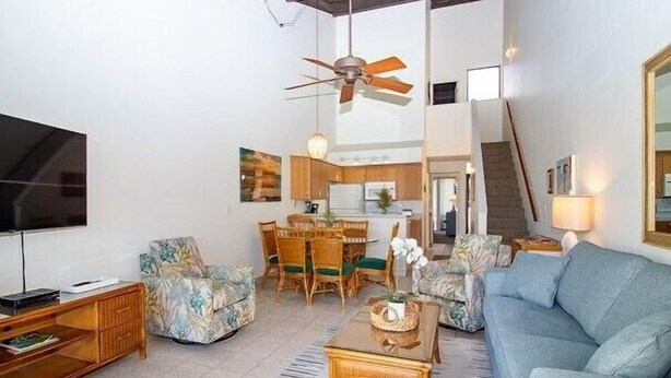A living room with a sofa, coffee table, TV, and a ceiling fan. - Island Retreat - Two bedroom Two bathroom Hale Kamaole 329 (Kihei)