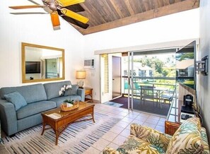 Ein Wohnzimmer mit einer Couch, einem Couchtisch und einem Deckenventilator.