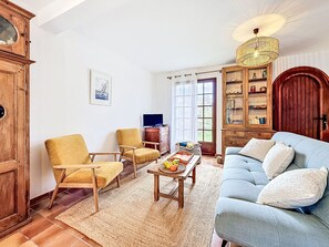 A living room with a sofa, two armchairs, a coffee table, a television, a wooden cabinet, and a large window. - La littorine by Interhome (Quiberon)