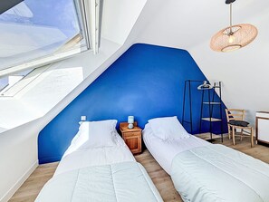 A bedroom with two beds, a window, a desk, a chair, and a hanging light fixture. - La littorine by Interhome (Quiberon)