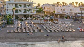 Un hôtel situé en bord de mer, doté de plusieurs espaces de détente, de parasols et offrant une vue sur l’océan.