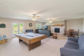 A pool table in a living room with a fireplace, a television, and a dining area. - Norris Lake House W Private Boat Slip & Game Room (LaFollette)