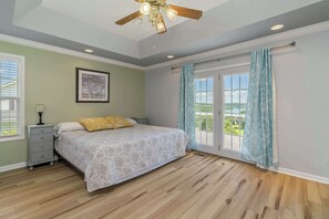 A bedroom with a bed, a nightstand, a ceiling fan, and a window with curtains. - Norris Lake House W Private Boat Slip & Game Room (LaFollette)