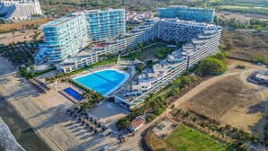 Ein großes Resort mit mehreren Hotelgebäuden, einem zentral gelegenen Schwimmbecken und einem Strandbereich.