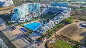 Ein großes Resort mit mehreren Hotelgebäuden, einem zentral gelegenen Schwimmbecken und einem Strandbereich.