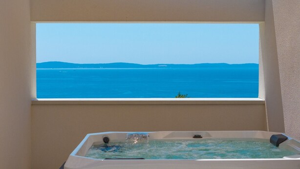 Une baignoire donnant sur la mer, avec une fenêtre.