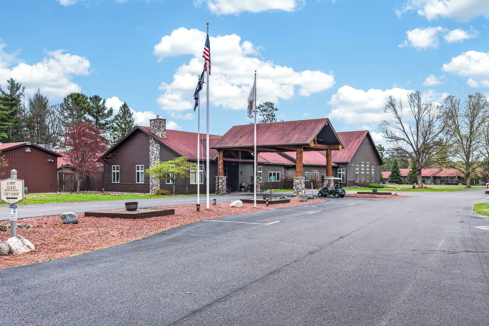Een lodge met een rood dak, stenen zuilen en een Amerikaanse vlag.