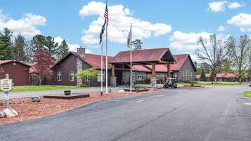 Een lodge met een rood dak, stenen zuilen en een Amerikaanse vlag.