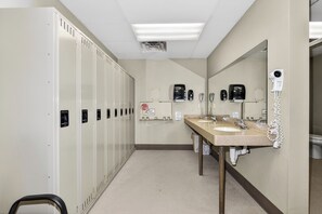 A hotel bathroom with lockers, a sink, a mirror, and a hairdryer. - Lake front 2-bedroom on the Eagle River Chain of Lakes with indoor pool and jacu (Eagle River)