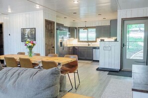A modern kitchen with wooden cabinets, a stainless steel refrigerator, and a window above the sink. - Modern Tyrolean Chalet Walk to Pool, Kayaks (Innsbrook)