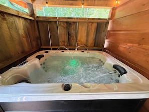Eine Holzhütte mit Whirlpool.