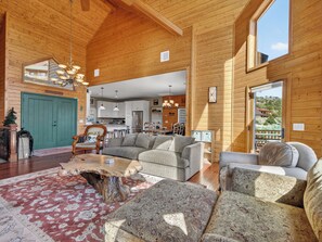 A spacious living area with a wooden interior, a dining table, and a sofa. - Panguitch Lake Cabin | Hot Tub + Fire Pit (Panguitch)
