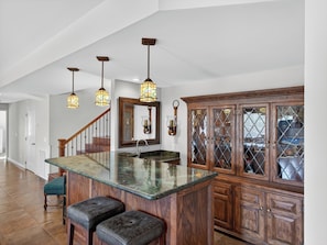 A kitchen with a central island, wooden cabinets, and pendant lighting.
