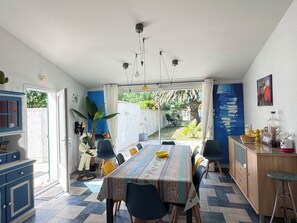 A dining area with a table, chairs, a bar, and a view of the outdoors. - The Lighthouse Villa (Saint-Denis-d'Oléron)