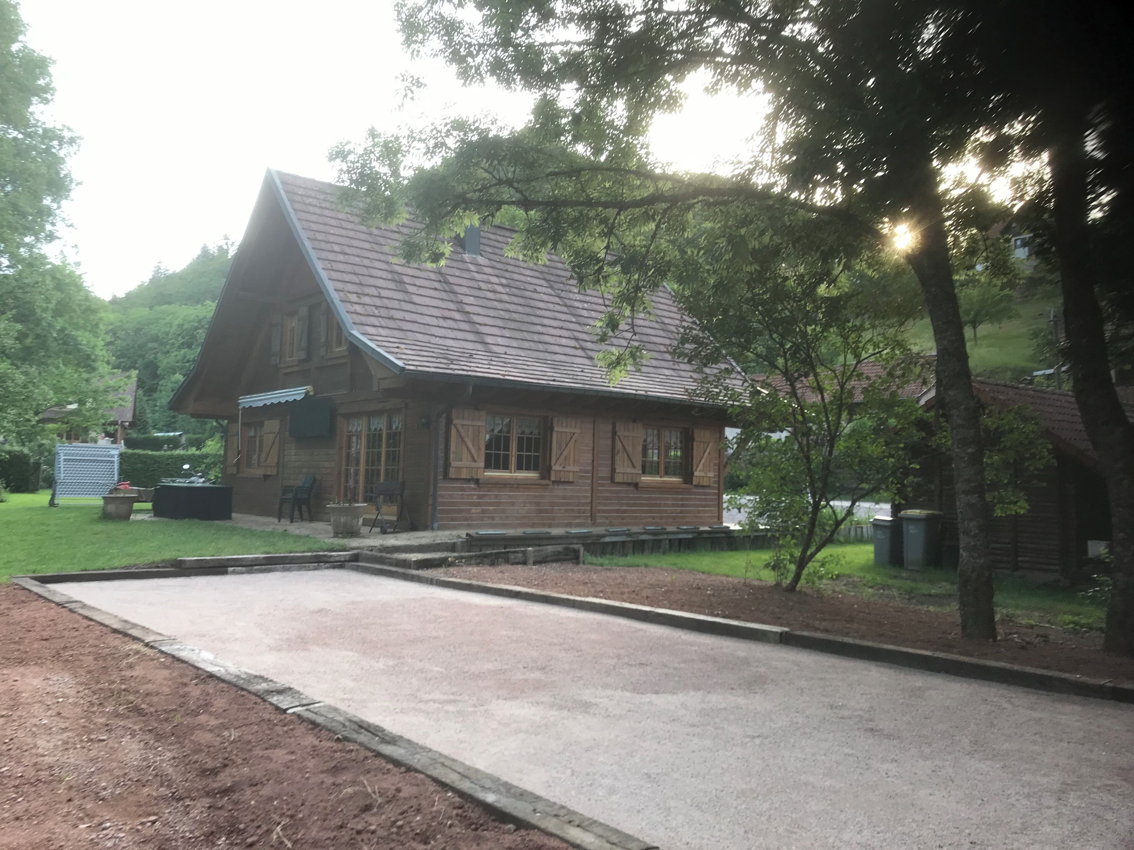 Une cabane en bois avec un toit en pente, une allée pavée et un petit espace porche.