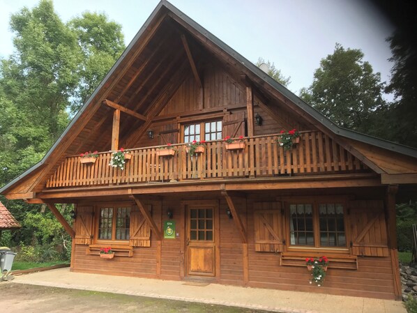 Eine Holzhütte mit Balkon, Fenstern und einer Tür.