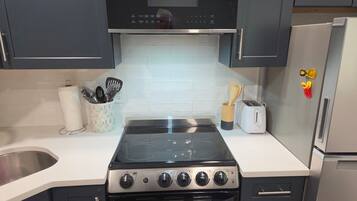 A kitchen with a stove, oven, and a toaster on the counter.