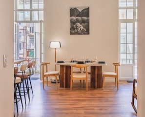 Ein Essbereich mit einem runden Tisch, Stühlen, einer Lampe und einem gerahmten Bild an der Wand.