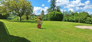 A well-maintained grassy area with a potted plant, trees, and a clear sky. - Large and peacefull house with a panoramic view of Belvès, in Black Perigord (Pays de Belvès)